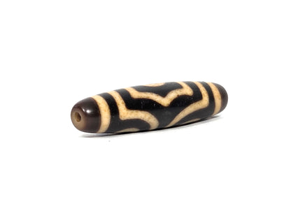At-090226-3E2 antique three eye dzi dark agate angled view opposite drill end wave cream detail, unretouche