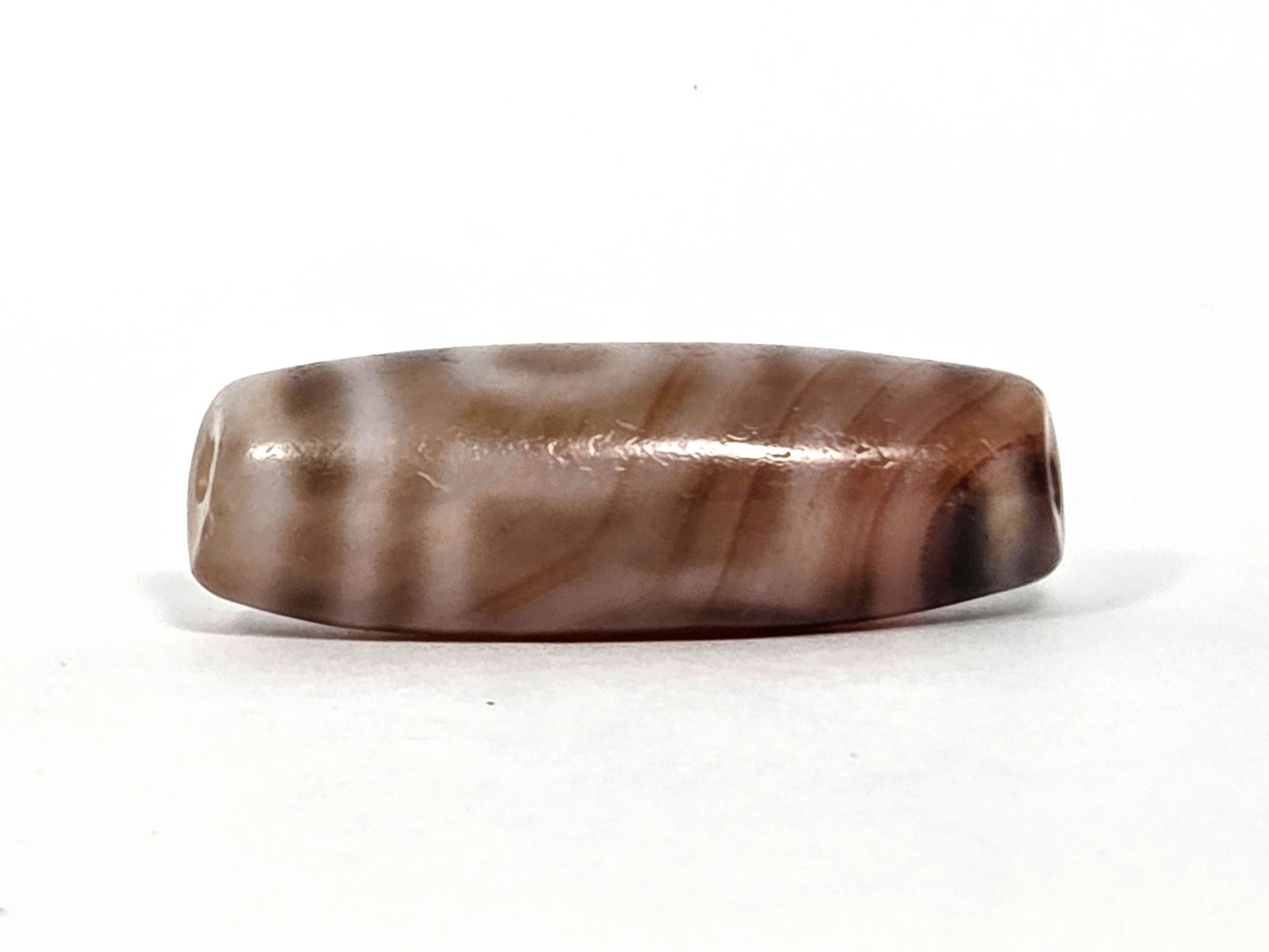 At-080426-2EBS antique two eye dzi bead 38.0×13.1mm, turn view showing cream-beige and brown agate banding running length of body, unretouched