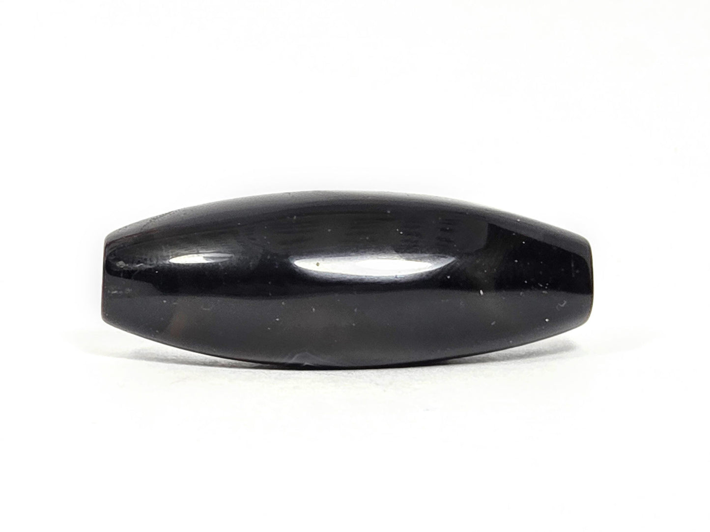 N-N-071126-1E-OLV3 back face, near-pitch-black ground, two faint surface marks disclosed, high gloss, unretouched