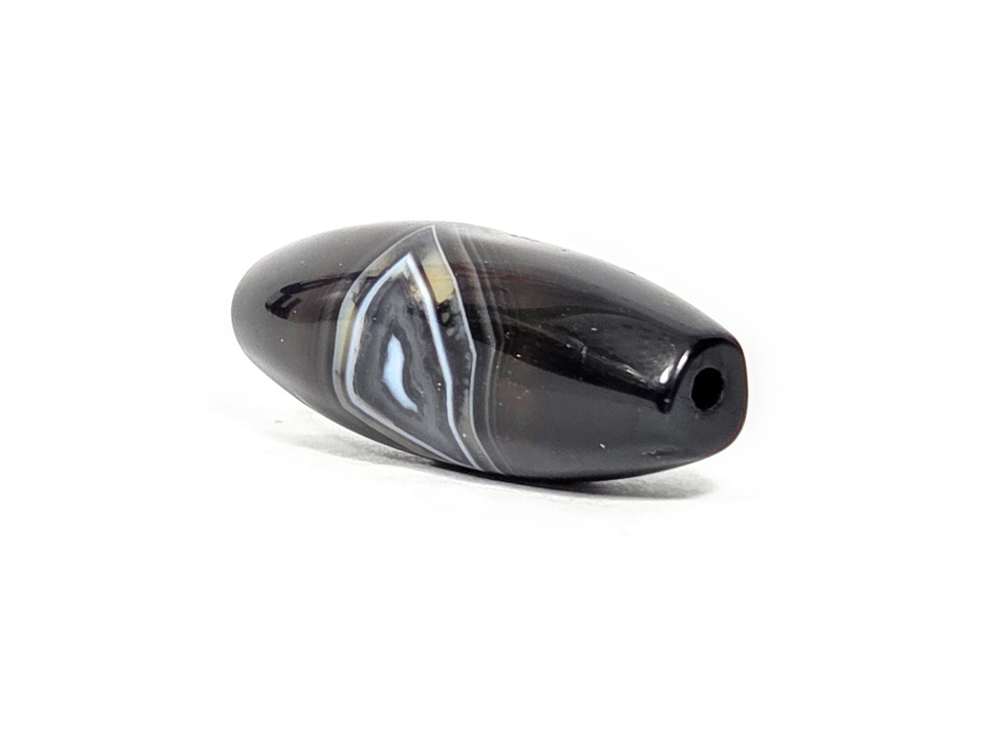 N-N-071126-1E-OLV3 three-quarter, narrow tapered drill-hole end, banding zone visible on body, unretouched