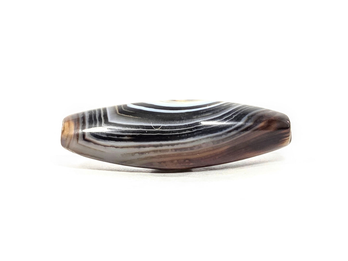 N-N-071126-1E-FCT upper side face, flat faceted surface, dense brown-black and grey-brown banding, warm honey-brown end, unretouched