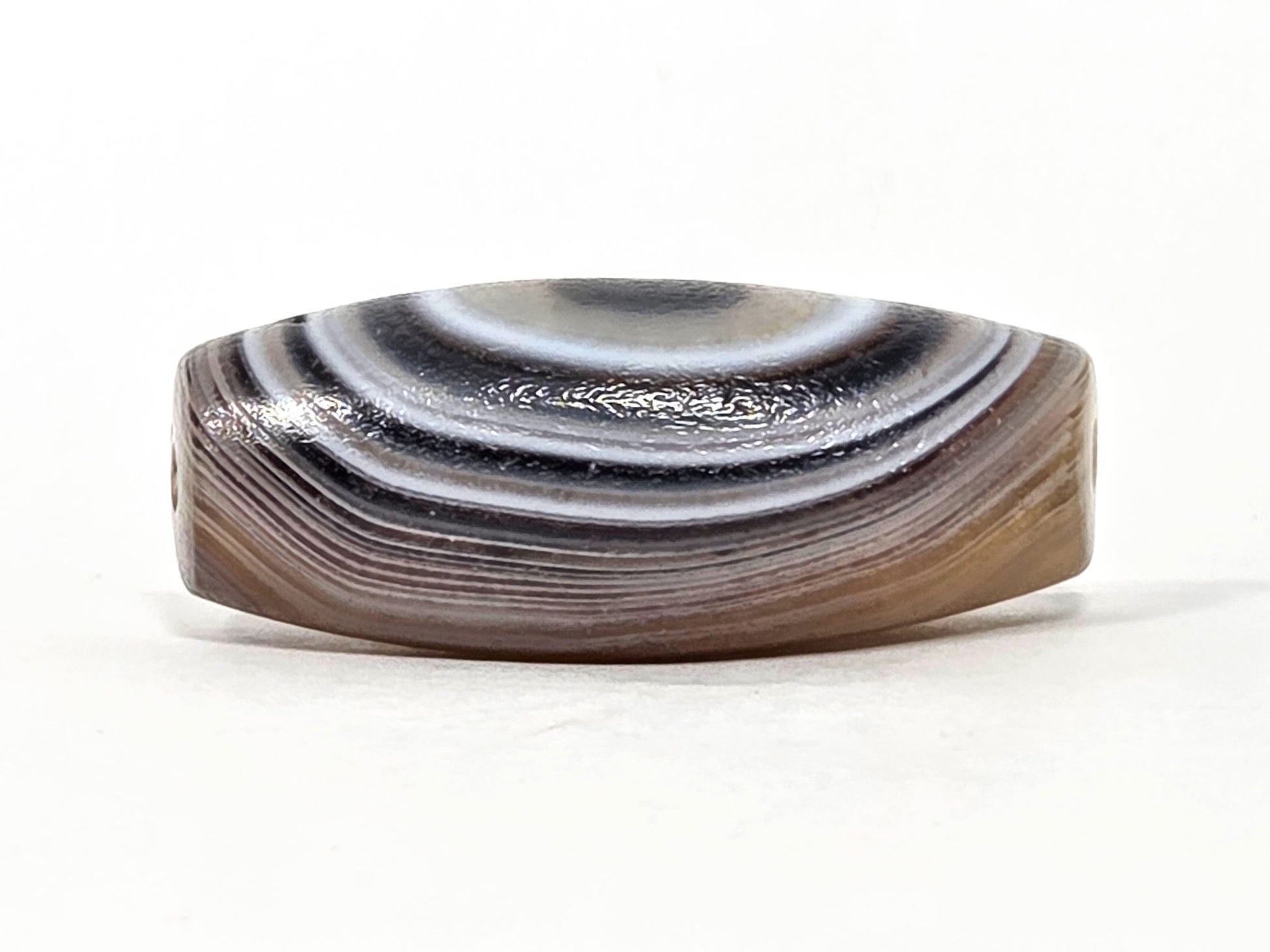 N-N-062126-1E2 dzi bead, side profile showing parallel diagonal banding, unretouched