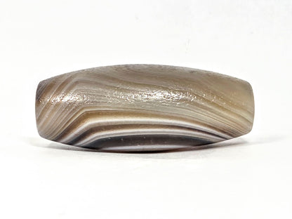 N-N-062126-1E2 dzi bead, angled side view, full band sweep visible, unretouched
