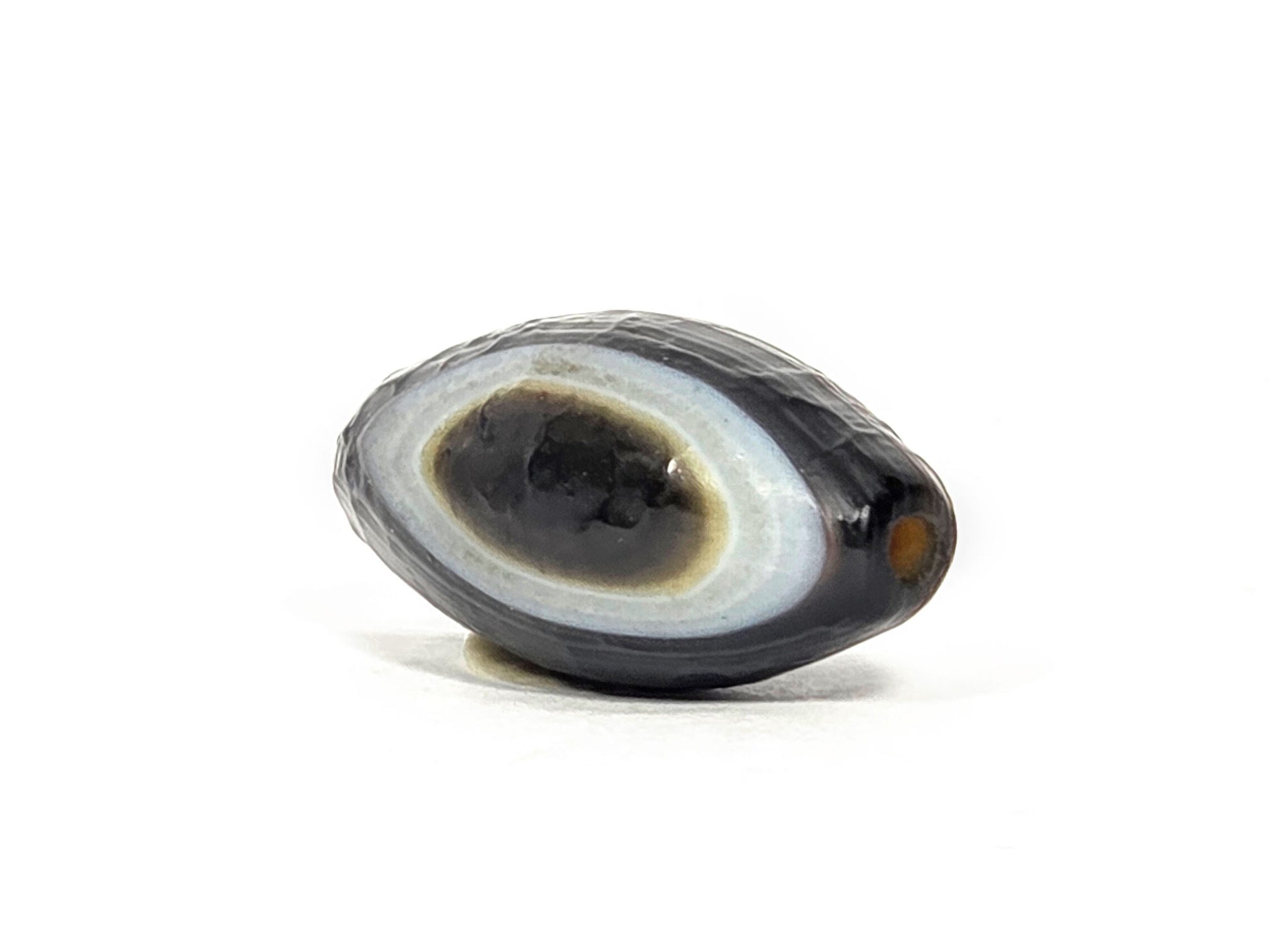 N-N-071026-1E-OLV natural one eye dzi angled view pointed drill end A eye face visible orange hole unretouched