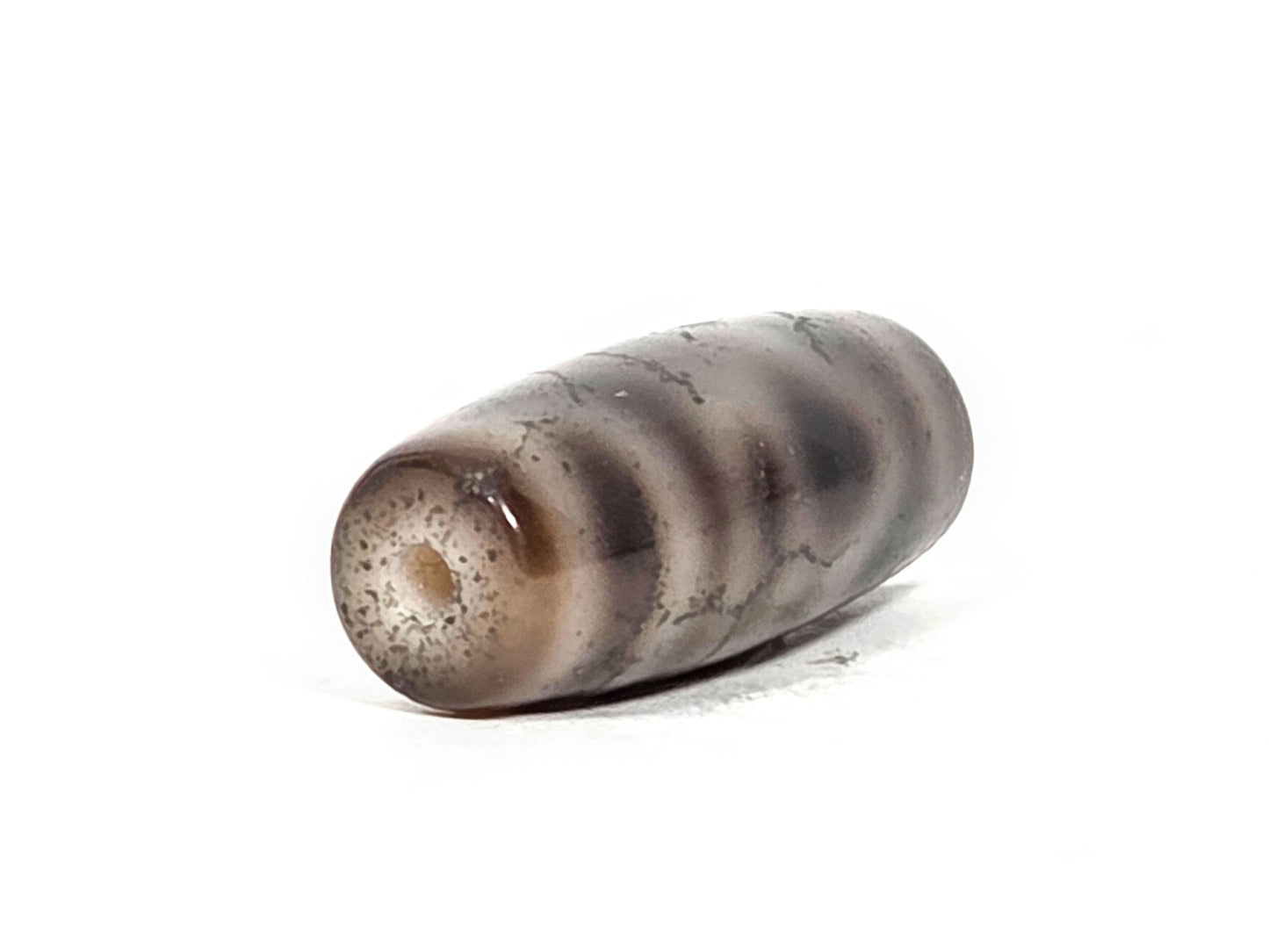 N-FA-071126-4ACT2 end view two, second drill hole, pronounced pitted crackle end cap surface, grey-brown agate, unretouched