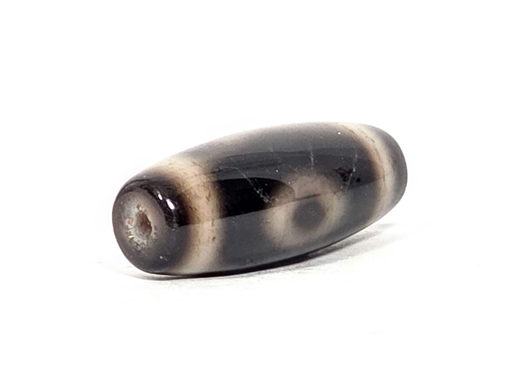 Two Eye motif N-FA-071426-2E drill end angle B — opposite end, dark cap, full body profile visible, unretouched.