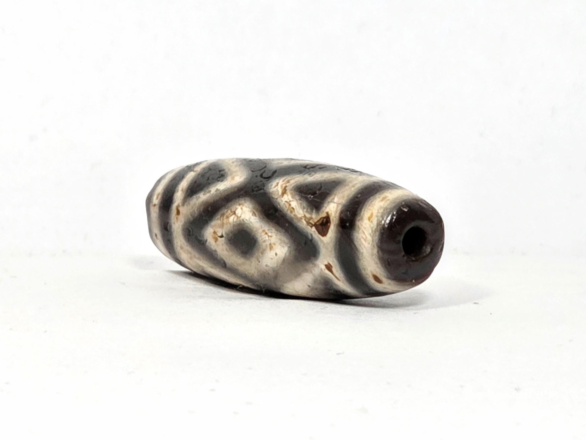 Ac-070926-3DE ancient three diamond eye tiger tooth dzi angled right drill end dark reddish-brown end cap unretouched