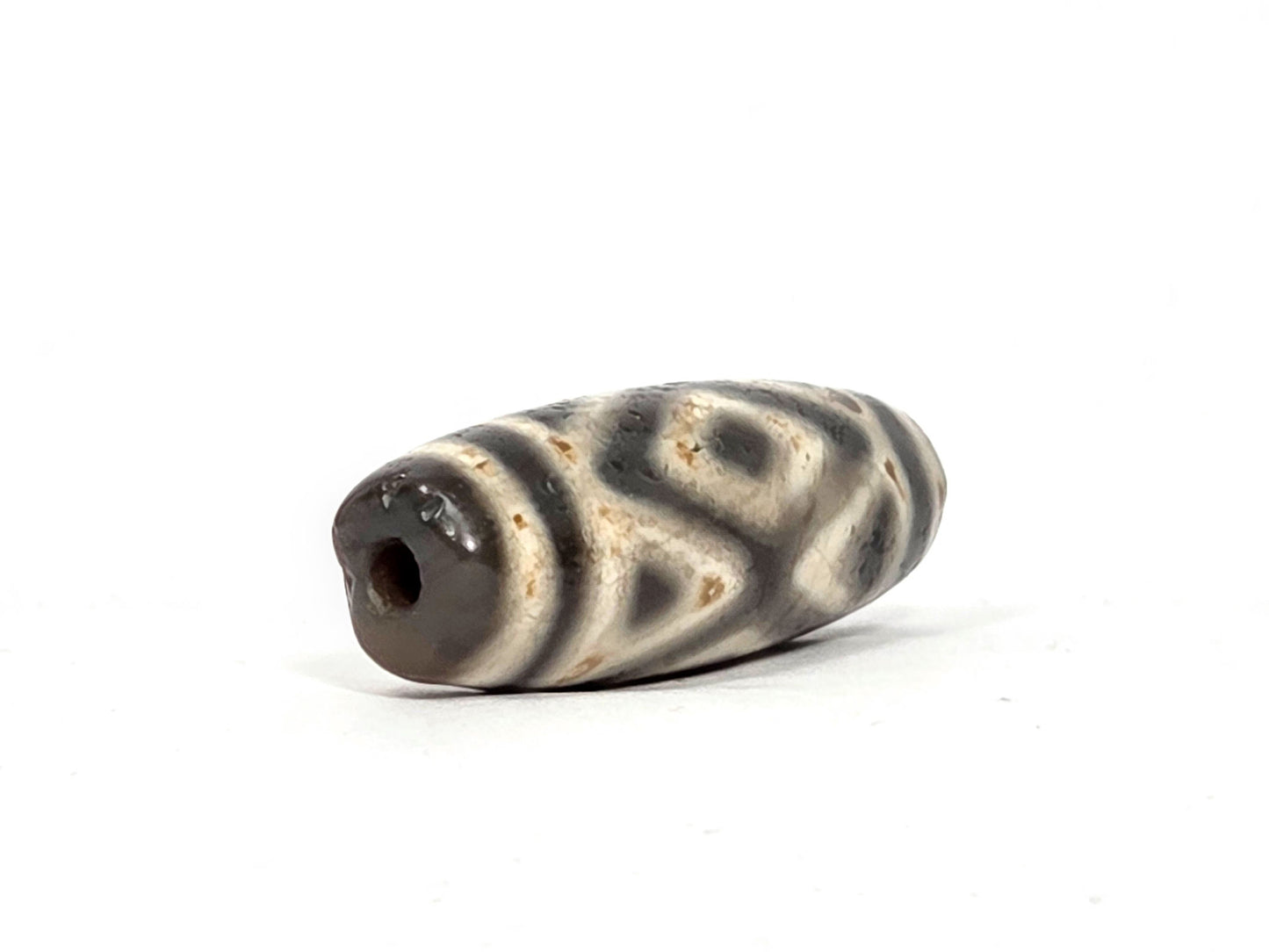 Ac-070926-3DE ancient three diamond eye tiger tooth dzi angled left drill end cream ground age texture unretouched