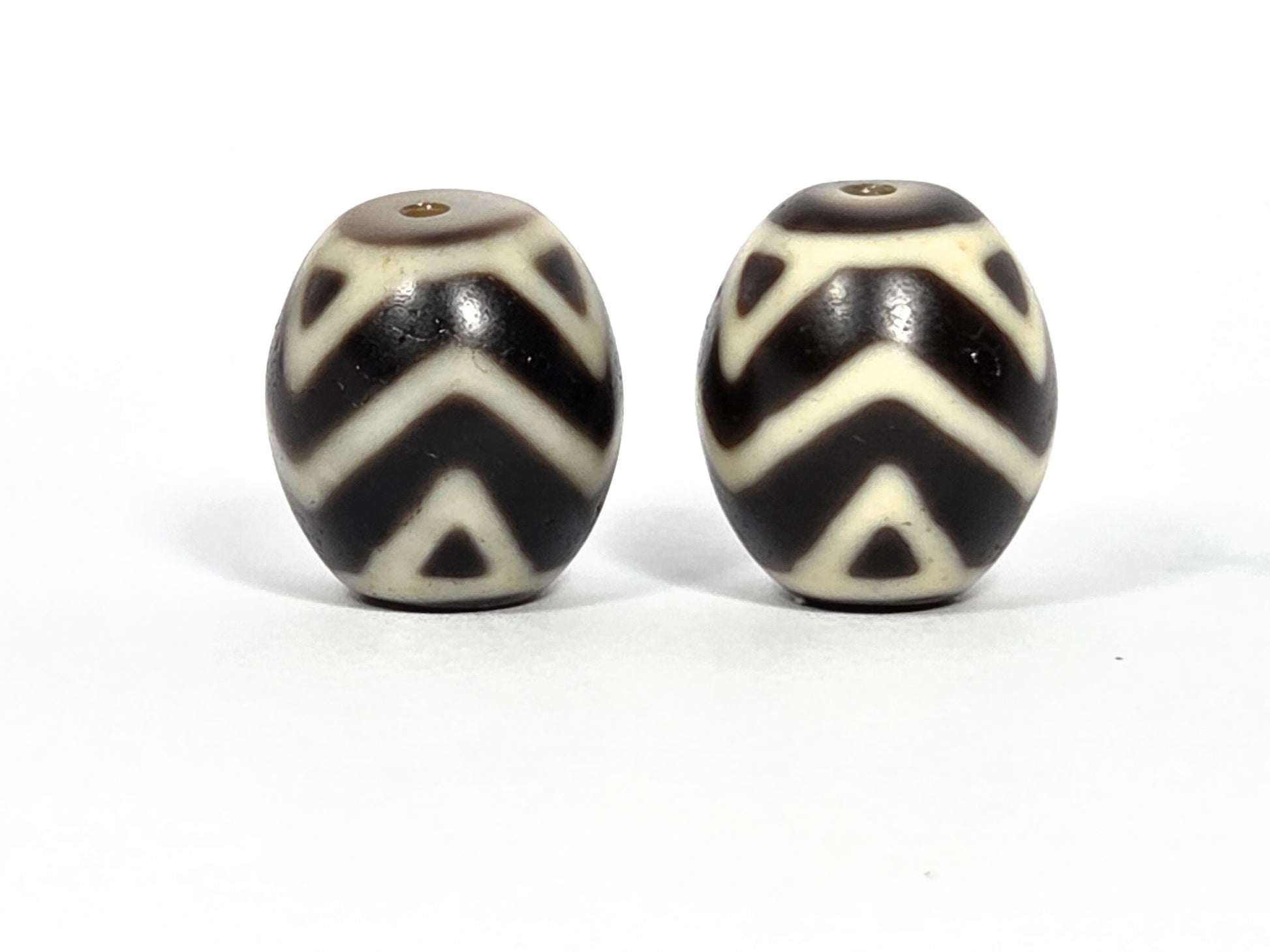 At-070626-TTW antique round Wave Tiger Tooth dzi bead pair, third rotation showing tiger tooth triangles at pole zones and chevron wave body, unretouched