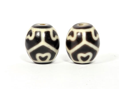 Antique Tibetan Six Eye Lotus round Dzi bead pair — third face showing continuous lotus motif wrapping the full bead body — both drill holes visible — unretouched photo — Ancient Dzi Shop