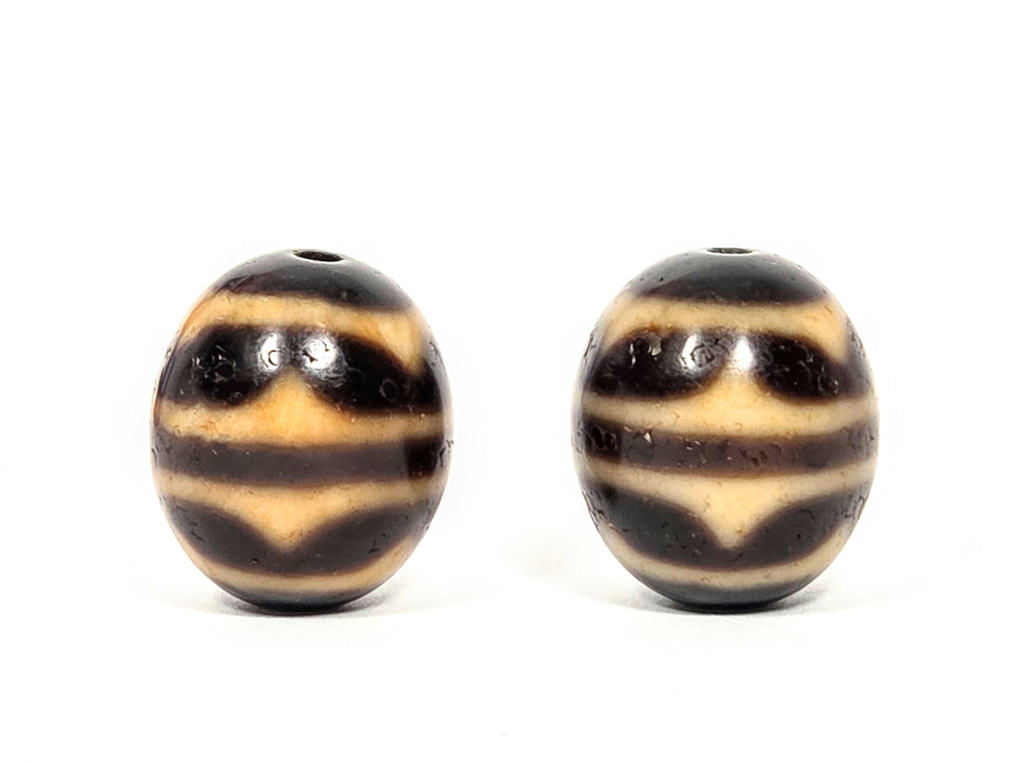 V-060426-DWP round dzi pair, diamond lozenge where waves meet, honey-tan on dark brown, unretouched