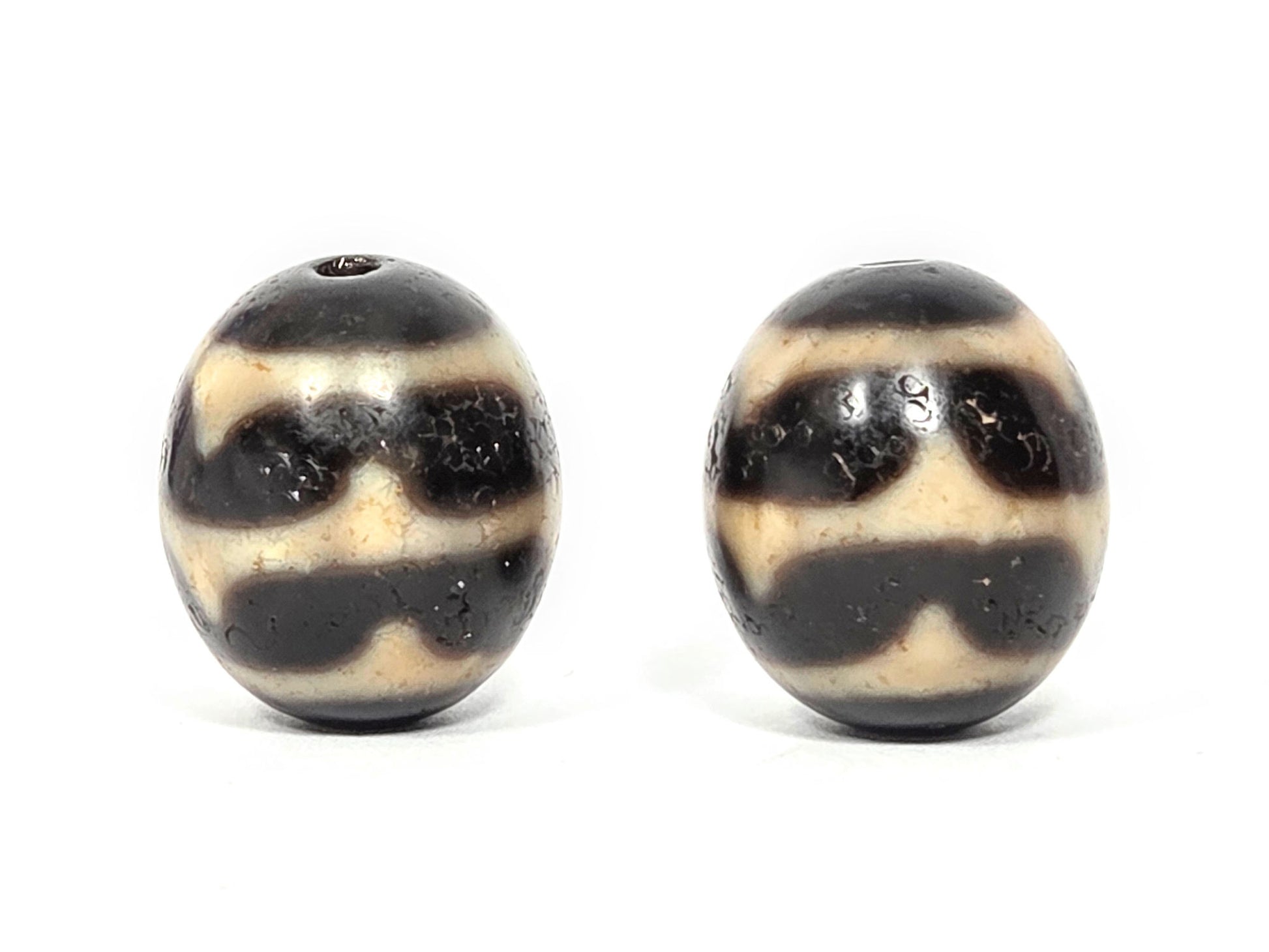 V-060826-DWP2 lateral face pair, pitch-black ground, micro-crazing visible on dark zones, sandy-cream waves, unretouched