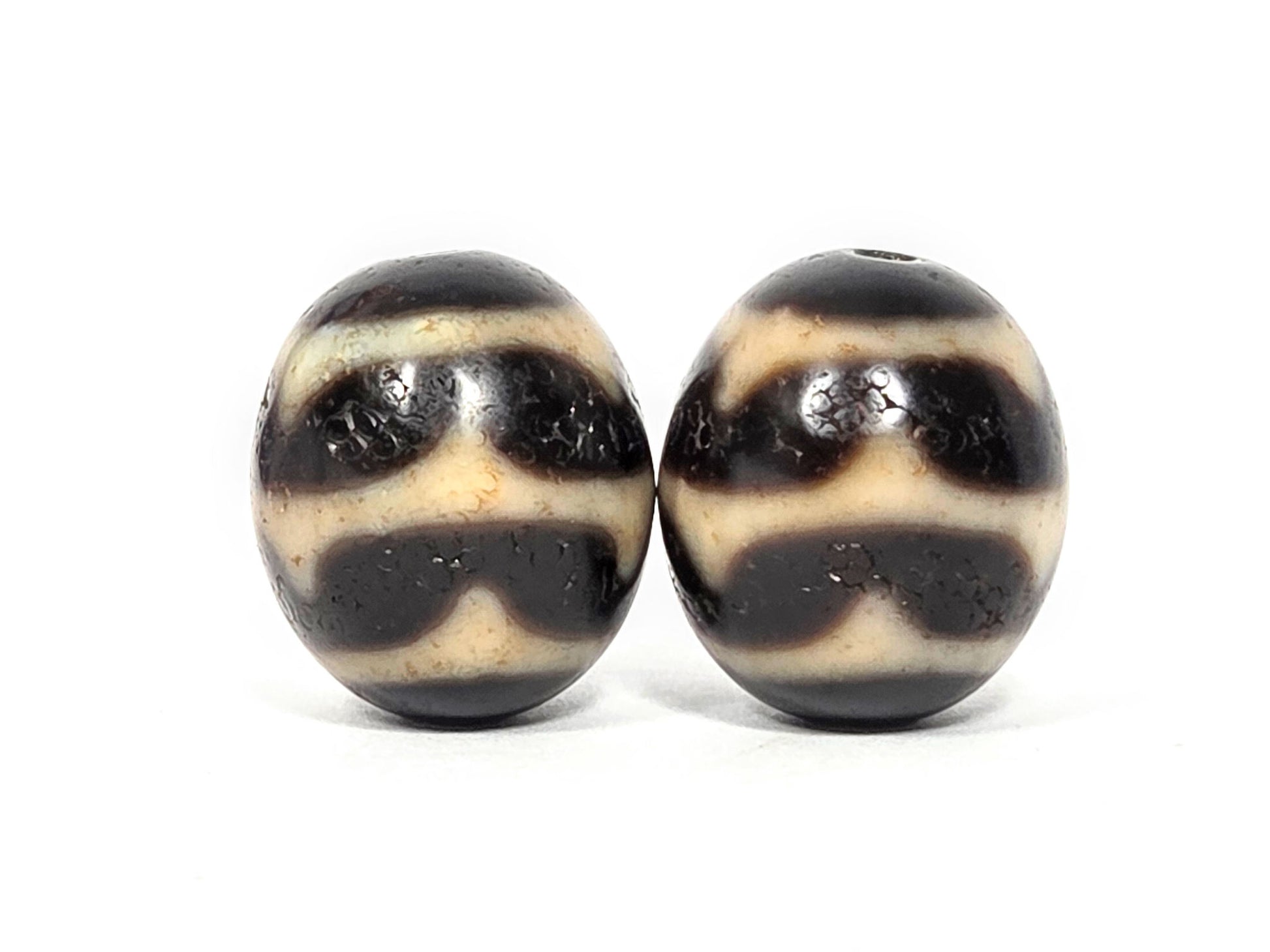 V-060826-DWP2 third face pair, near-spherical form confirmed, pitch-black, double wave arch visible, unretouched