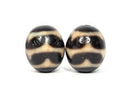V-060826-DWP2 third face pair, near-spherical form confirmed, pitch-black, double wave arch visible, unretouched