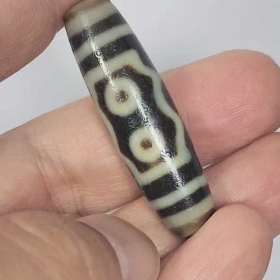 Video of antique Tibetan five eye Kubera dzi At-072625-5E rotating 360°, two eyes + frame face, triple wave face, three eye colonnade face, pitch-black agate, 44.5mm, unretouched footage