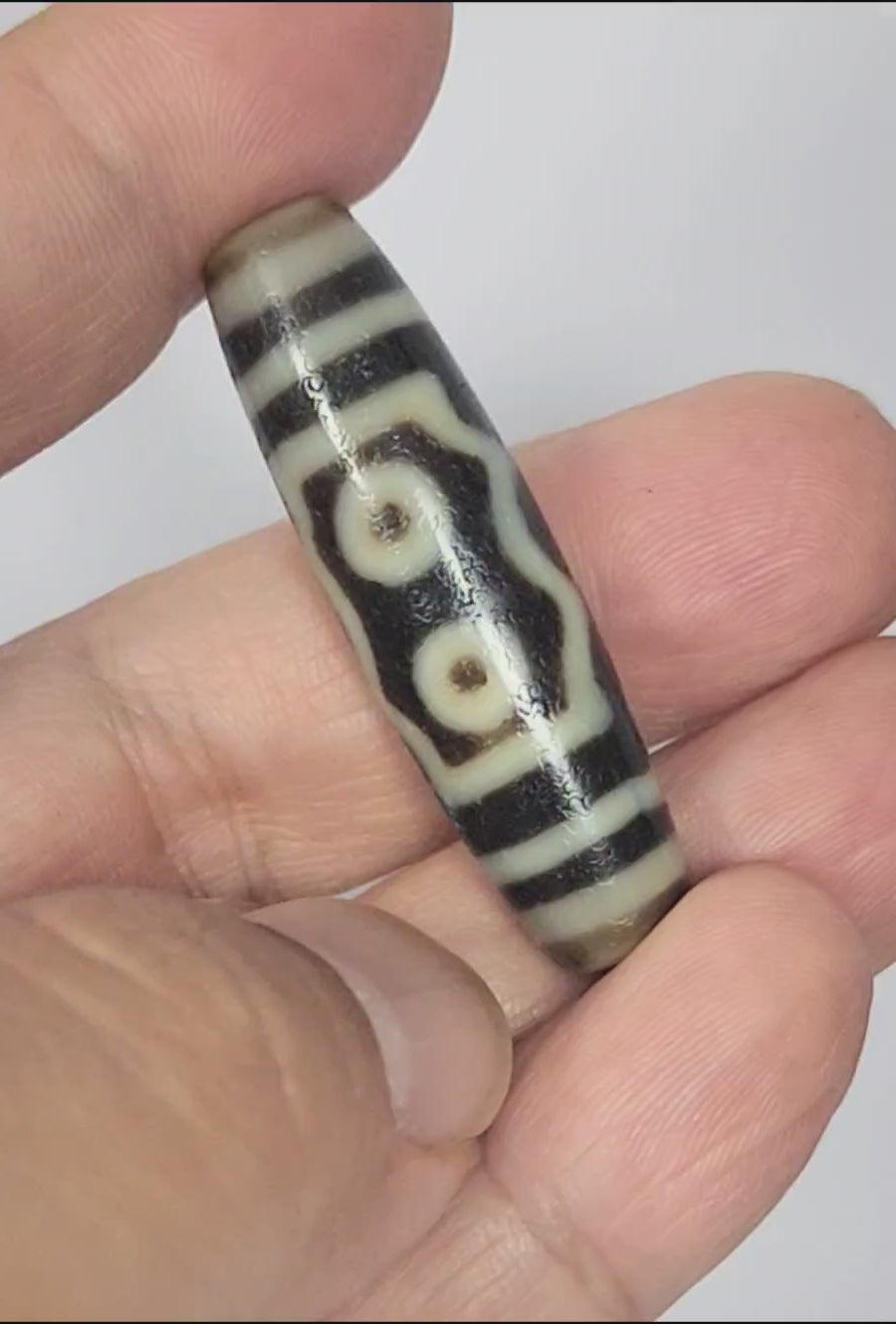 Video of antique Tibetan five eye Kubera dzi At-072625-5E rotating 360°, two eyes + frame face, triple wave face, three eye colonnade face, pitch-black agate, 44.5mm, unretouched footage