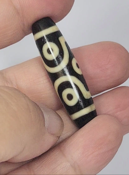 Video of antique Tibetan six eye dzi At-042925-6E2 rotating 360°, pitch-black agate, bold scroll paired eyes and diamond frame single eyes, 41.4mm × 11.4mm, unretouched footage