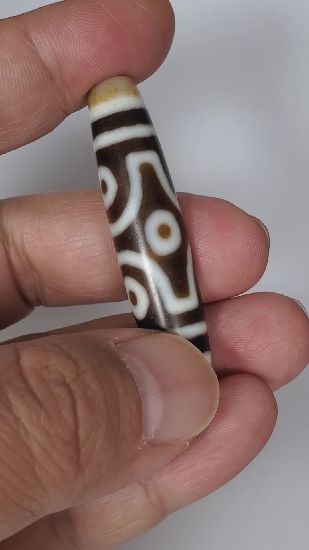 Video of antique Tibetan six eye dzi At-053026-6E rotating 360°, four faces — diamond frame, open-ring pair, closed-ring pair, honey-gold end caps, deep brown agate, 54.9mm, unretouched footage