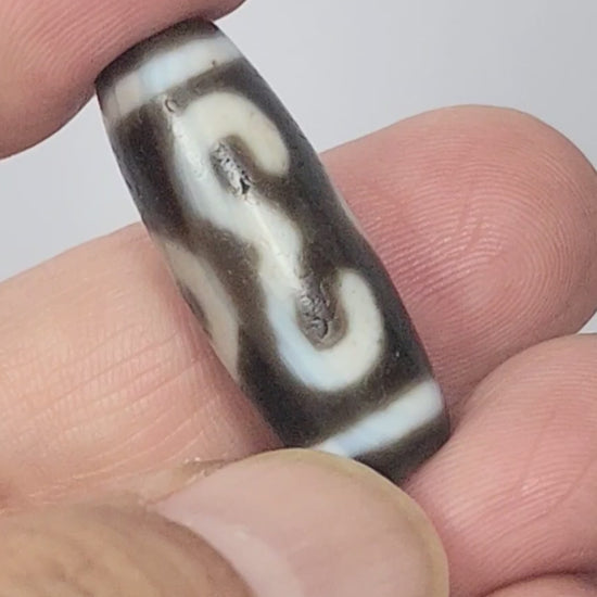 Video of antique Tibetan Double Bat Two Eye dzi At-060725-DB2E2 rotating 360°, calligraphic double bat and eye motifs, grey-brown agate, bloodspots, 31.5mm × 11.6mm, unretouched footage