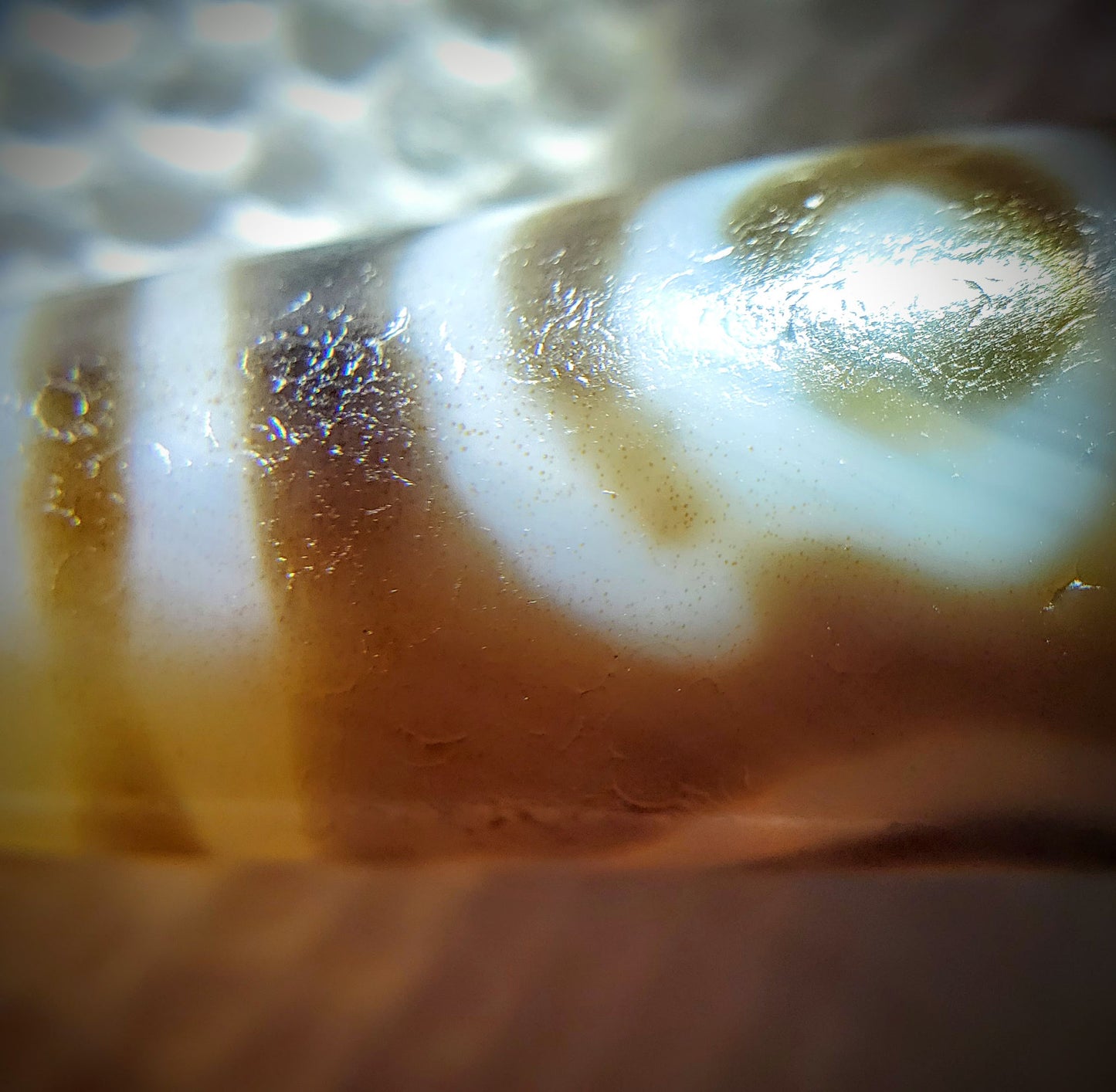 At-061926-PDEBS macro, warm translucent glow under raking light, cinnabar specks visible, unretouched