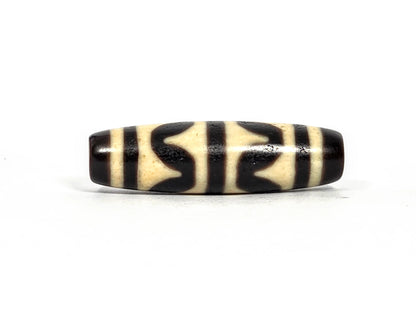 Third lateral profile of antique double wave dzi bead (AT-092826-DW) showing full motif composition, deep black wave forms on cream-white ground, 41.1 mm × 11.7 mm
