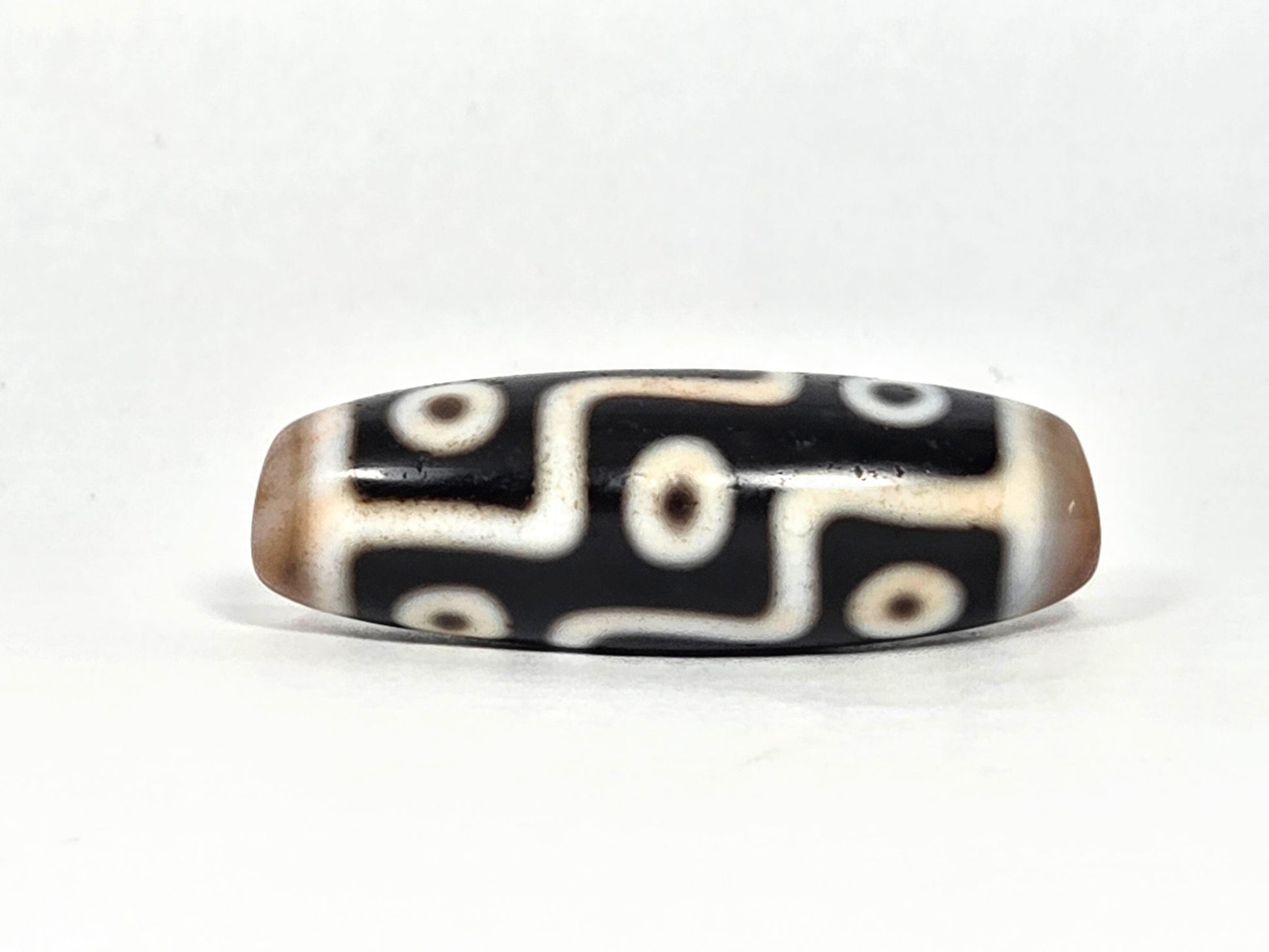 At-070626-9E2 nine eye dzi face C, pitch-black agate, warm brown end caps, cream eye network, unretouched