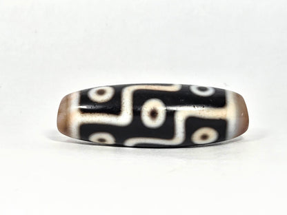 At-070626-9E2 nine eye dzi face C, pitch-black agate, warm brown end caps, cream eye network, unretouched