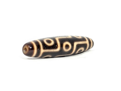 At-070626-9E antique nine eye dzi, angled view drill end A, warm reddish-brown domed end cap, small centred hole, unretouched