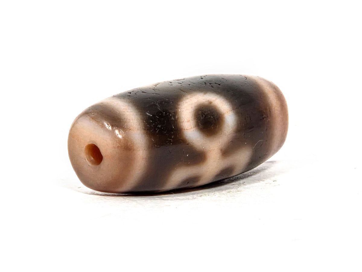V-071426-BNF end angle A — warm peachy-brown end cap, small clean drill opening, motif visible, unretouched.