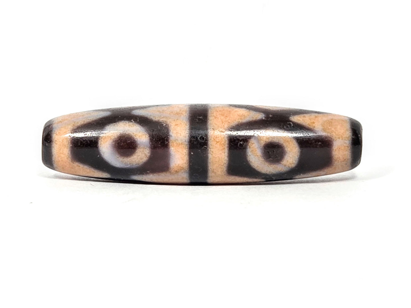 V-061026-6ETTBS face C, warm cinnabar-peach field, white-cream eye rings, tiger tooth chevrons, unretouched