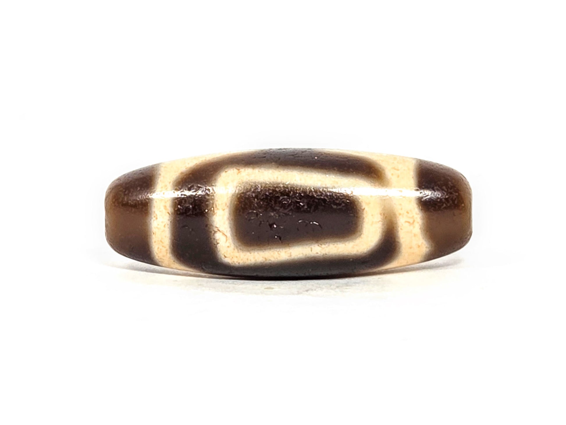 V-071126-HE opposite primary face C, angular oval reading, cream band enclosing dark interior, warm dark brown, unretouched