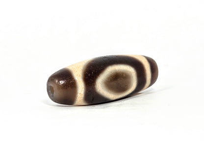 V-071126-HE opposite end, dark brown end cap, second drill hole, oval motif with cream enclosing band visible, unretouched