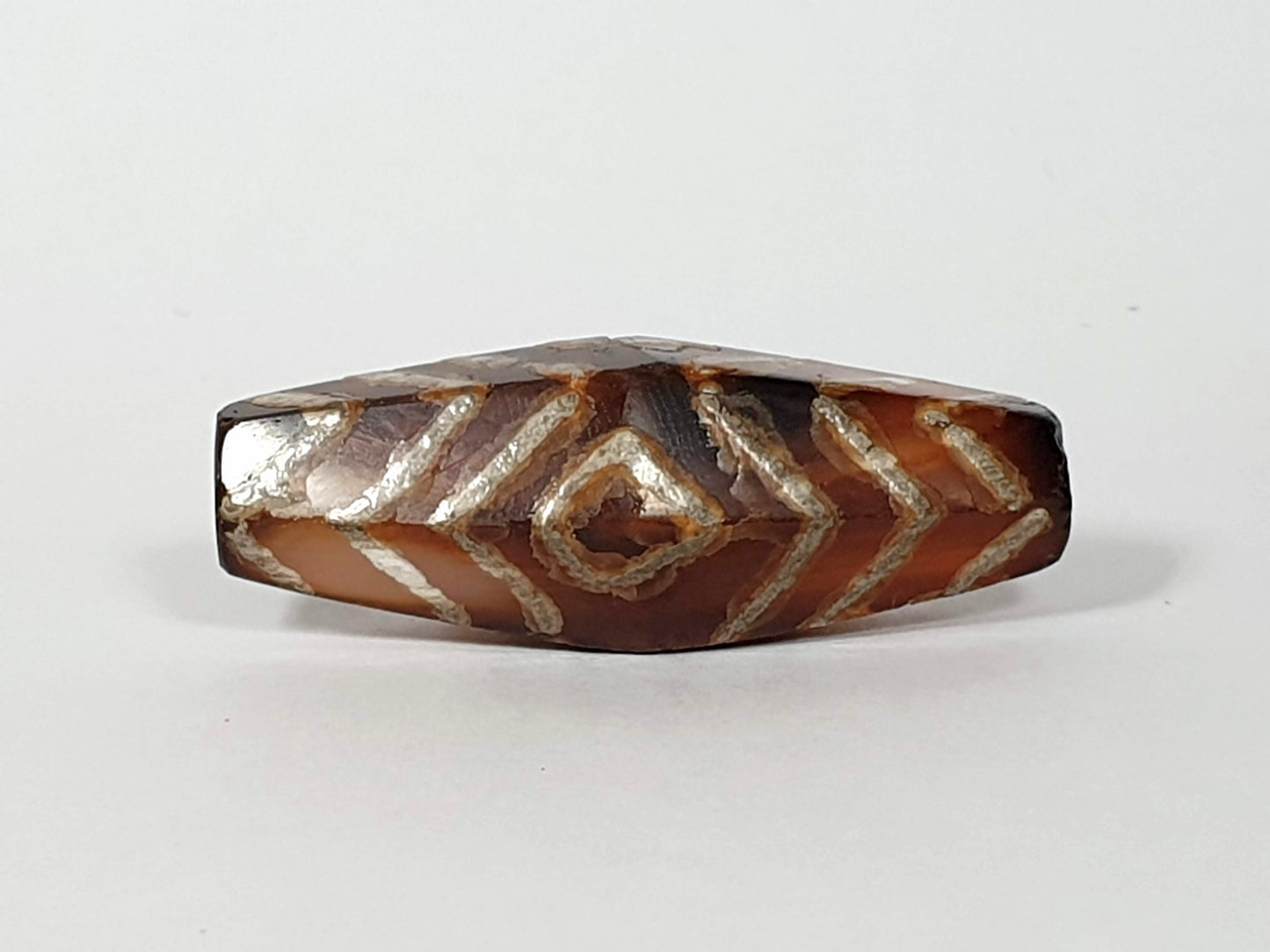 Ancient carnelian dzi bead with three eye and tiger stripe motif — rare hexagon shape in natural Himalayan carnelian agate