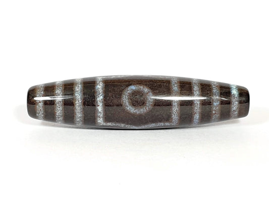 A polished agate bead with three eye motifs and bloodspot patterns.